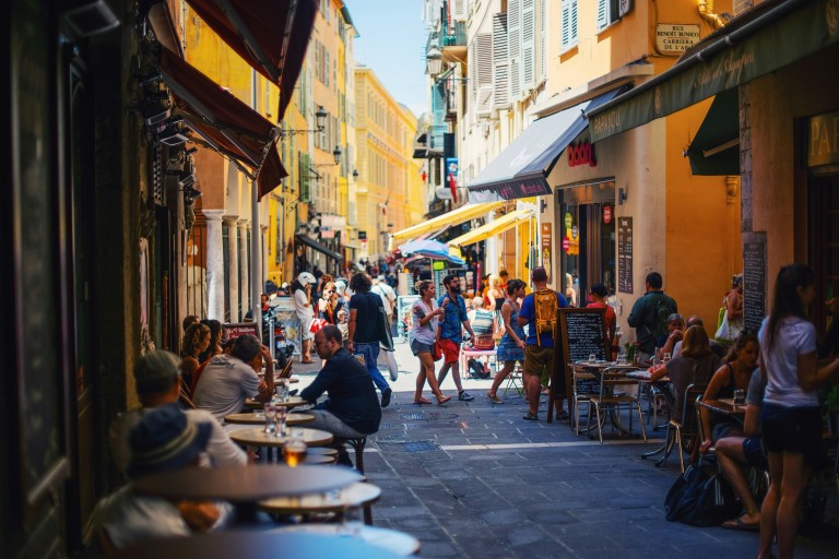 Smal gade med cafeer i Nice, Frankrig