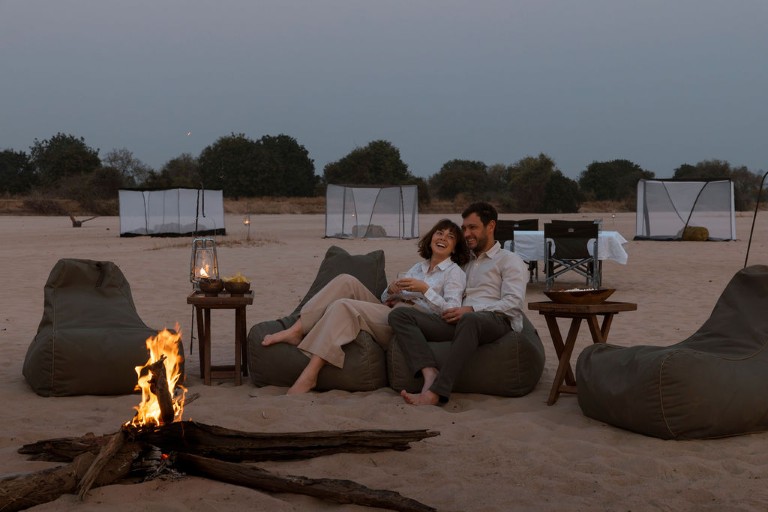 Hygge ved bålet på Time + Tide Sleepout Under the Stars, Zambia, Afrika